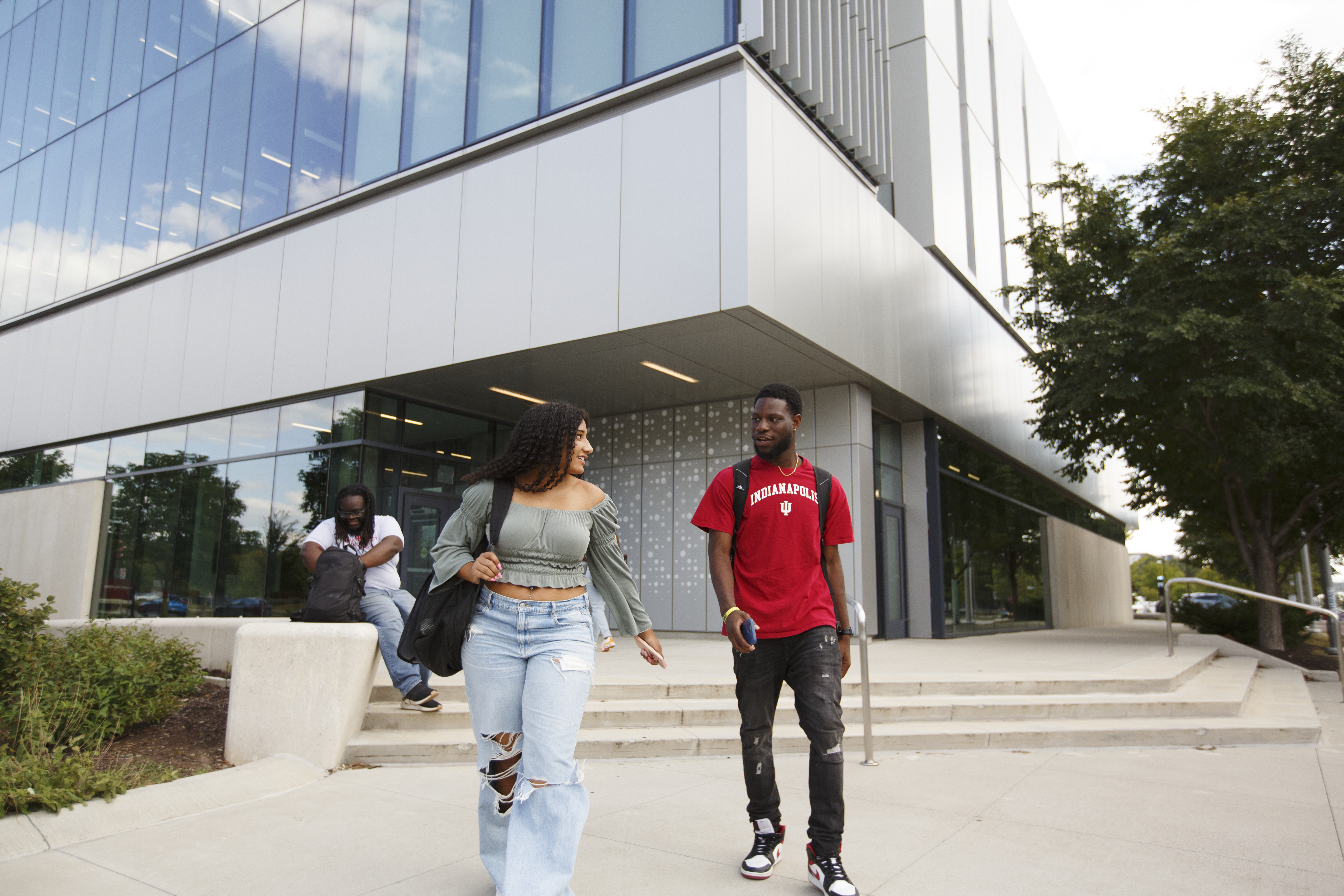 Two people walking out of Innovation Hall, talking.