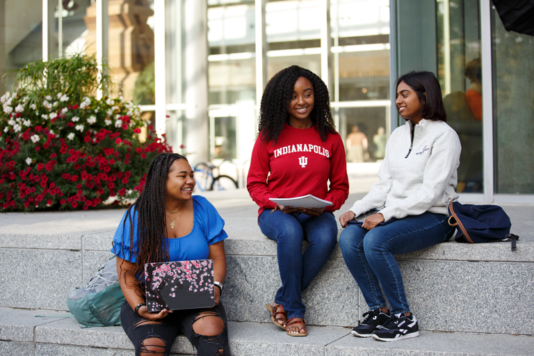 A group of students sitting on stone steps