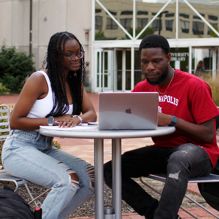 Two students looking at a laptop