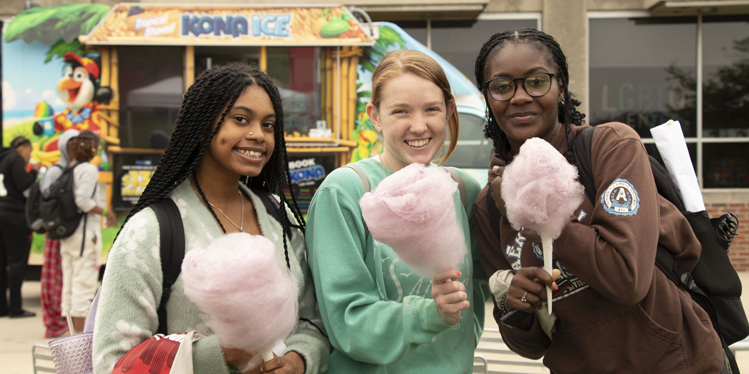 Students smiling and holding cotton candy