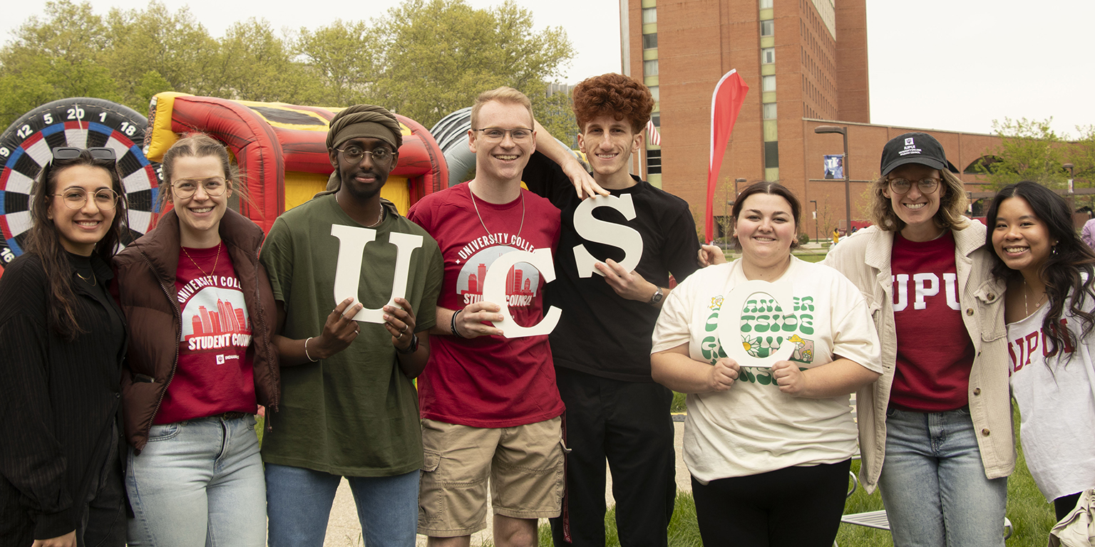 Students smiling and holding block letters UCSC