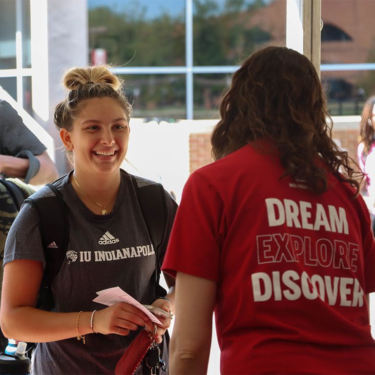 A woman smiling as she talks to another person.